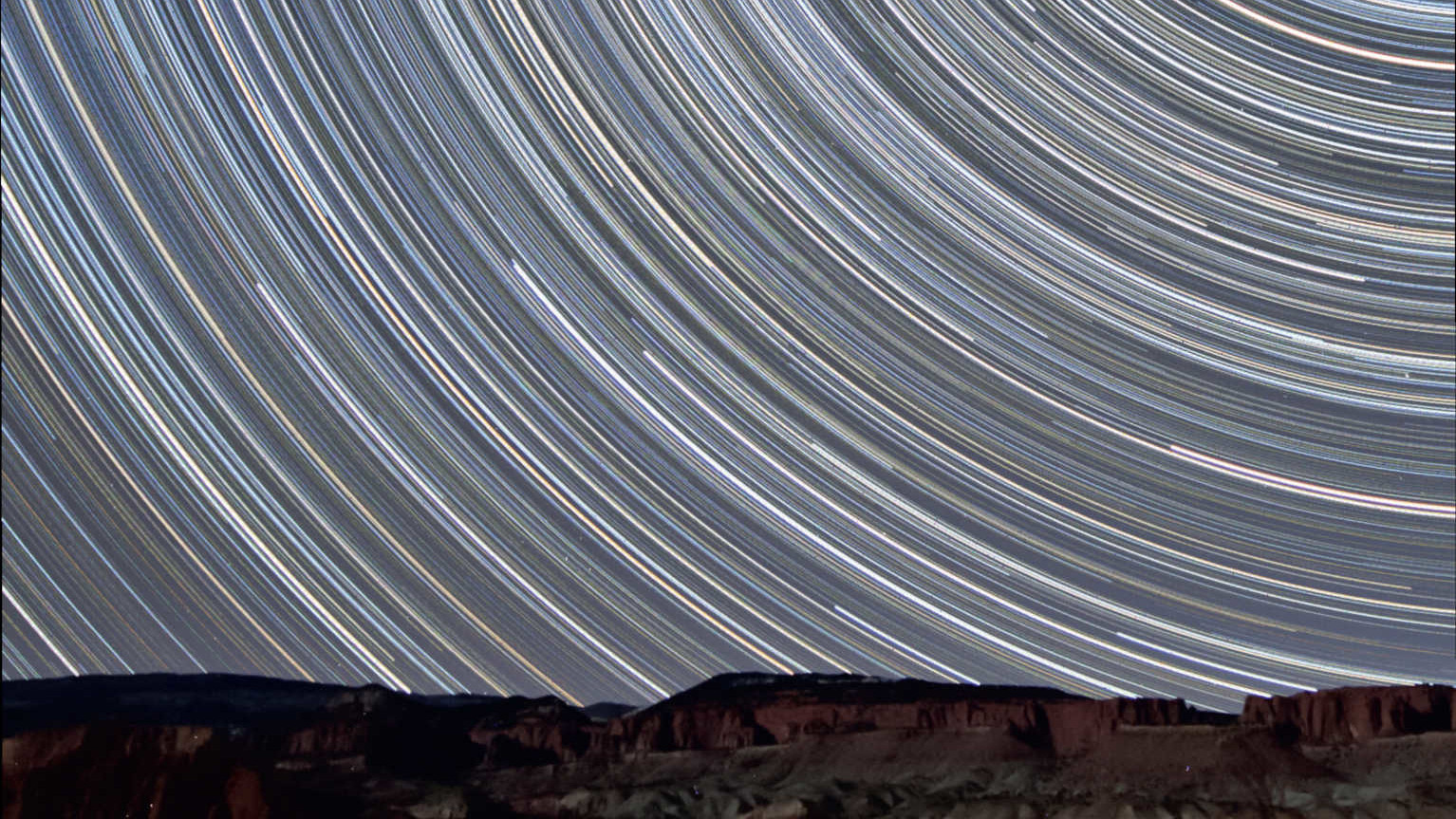 A few miles from the Capitol Reef National Park in Utah (USA), these star trail shots were taken looking north, showing the movement of stars over the red sandstone rock lit by the waxing Moon. This composite image consists of 350 shots with an exposure time of 90 seconds each (total exposure time: 525 minutes = 8.75 hours). The resulting image was created with a 10-20mm lens (at 10 mm and f/4) on a Canon 450D DSLR. U. Dittler